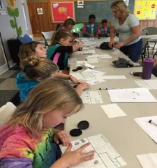 girl scouts take their own fingerprints at a workshop