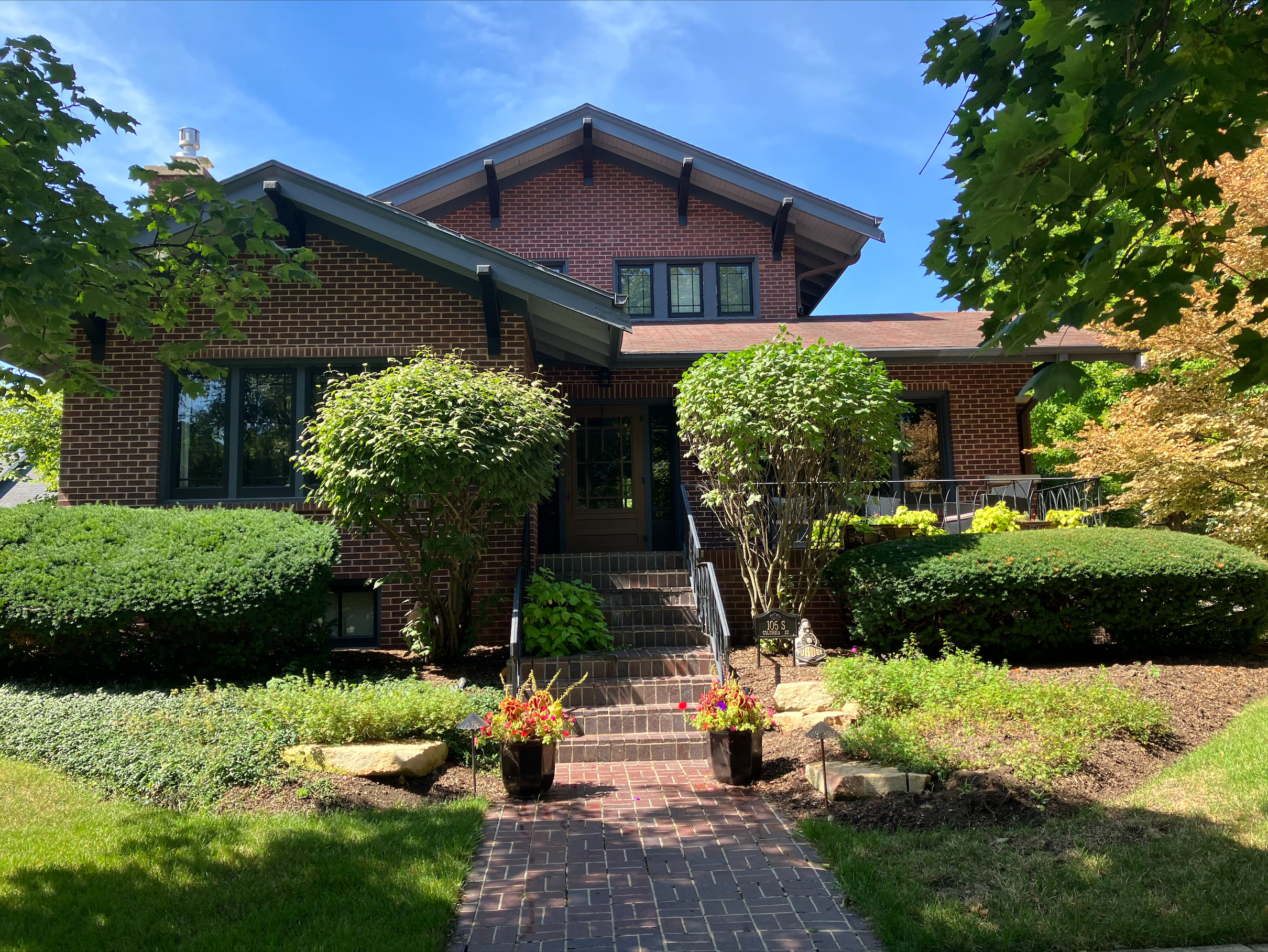 Brick steps lead up to a brick split-level historic home in Naperville.