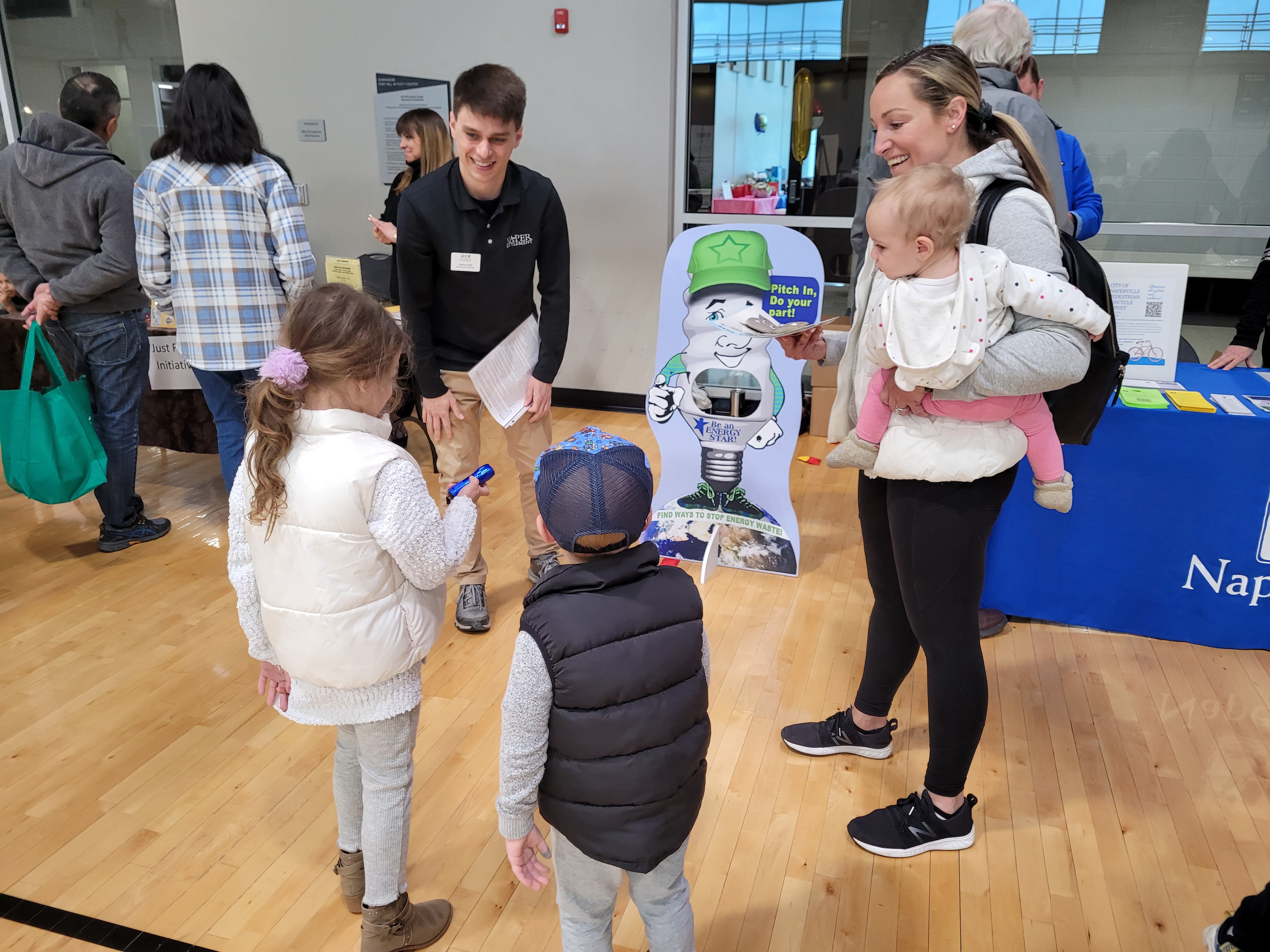 an employee speaks to a mom and three young children at an open house
